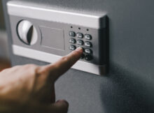 A business owner or employee opening a safe with a keypad combination lock